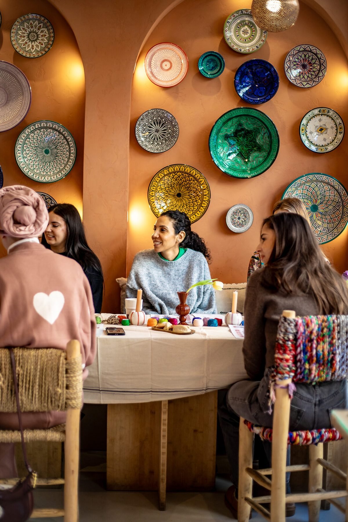 Participantes réunies autour de la table, dans la salle aux murs terracotta et céramiques