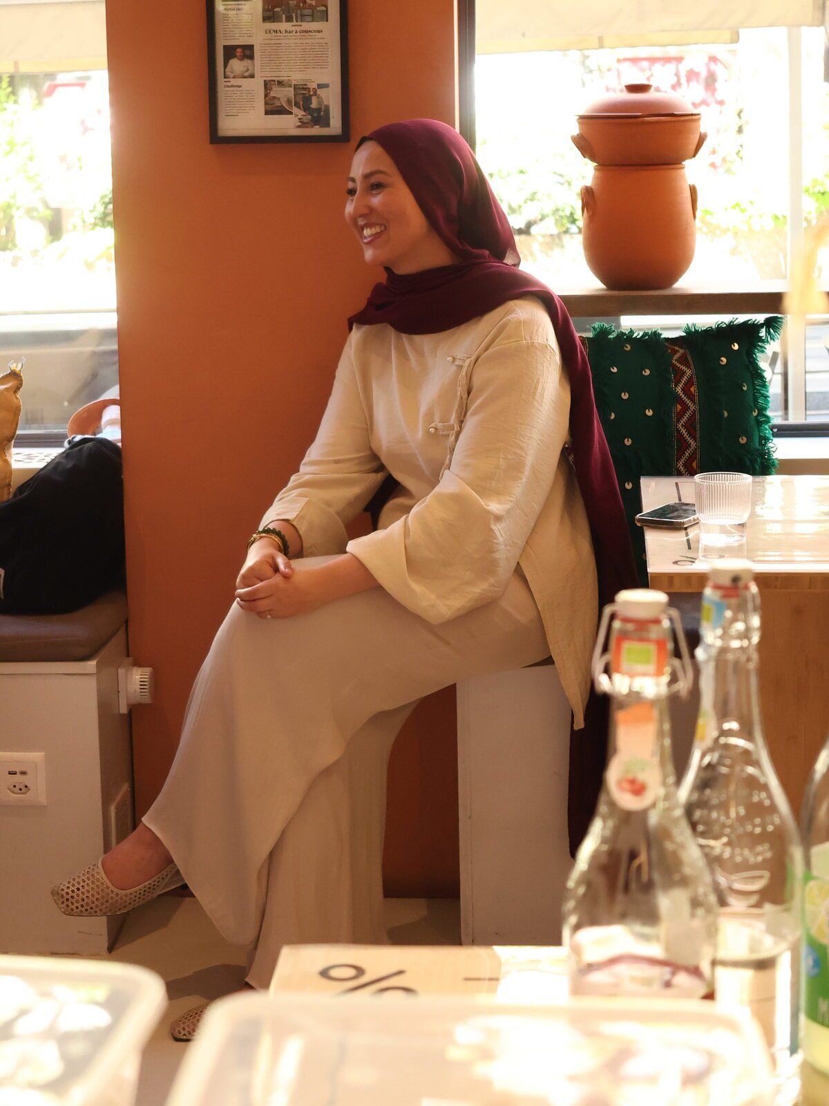 Rania, fondatrice de With Nürya, assise dans le lieu d'accueil des ateliers